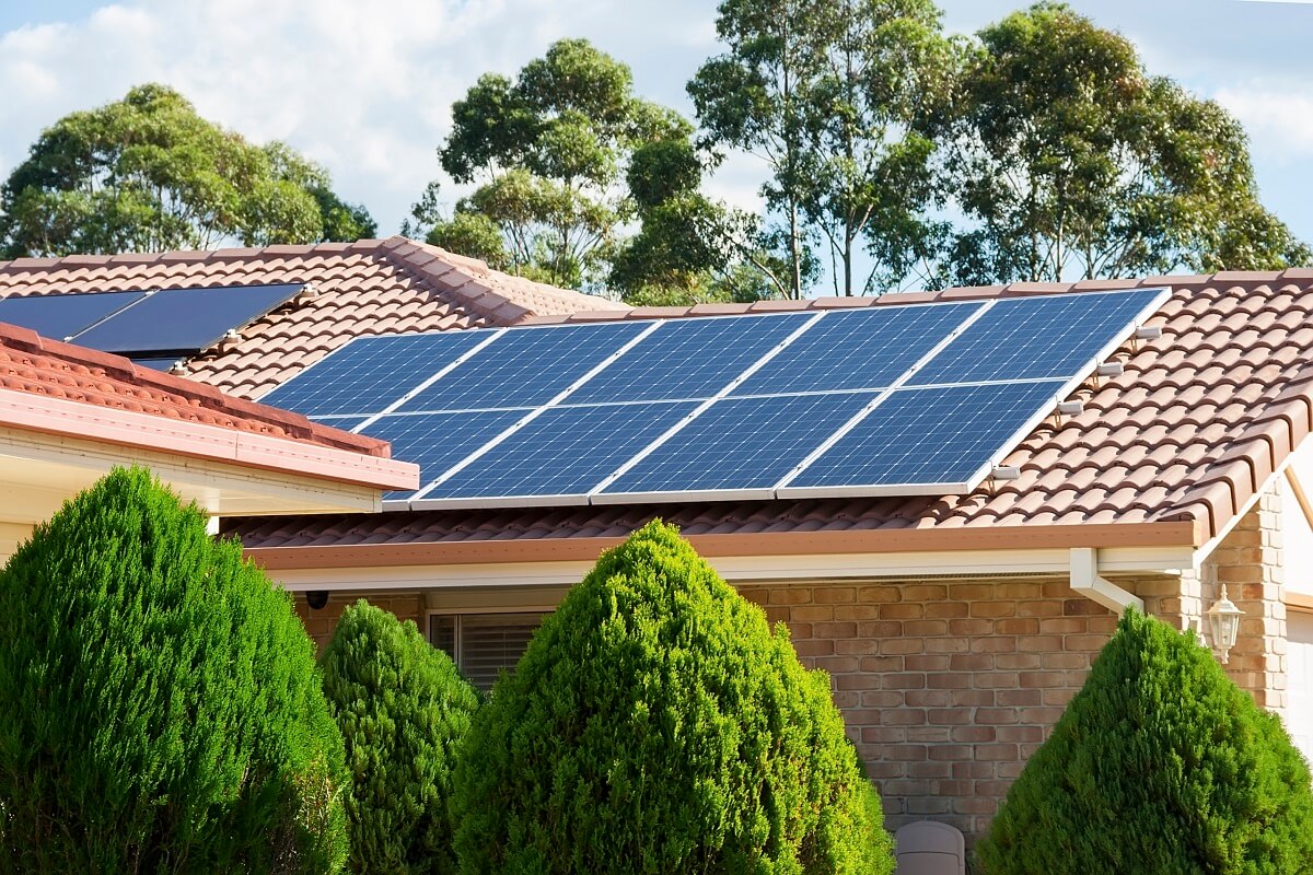 paneles solares sobre el tejado de una casa para saber cuantas placas solares necesito